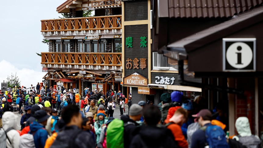 A crowd of mountain climbers gathered outside an inn in Japan's Mount Fuji