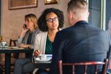 A woman sitting across from a man in a cafe setting to depict racism in online dating.