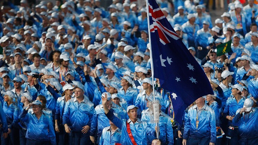 James Tomkins carrying an Australian flag and leading the athletes out at the opening ceremony in 2008