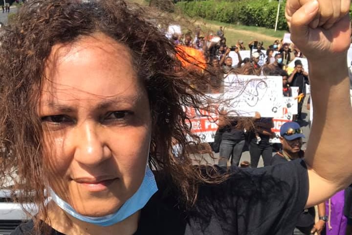 Tania Nugent is pictured staring at the camera at a rally with her fist up. 