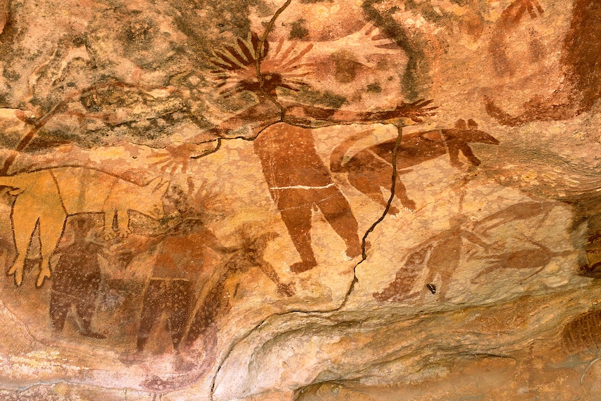 Rock art of a person andanimals in Quinkan Country.