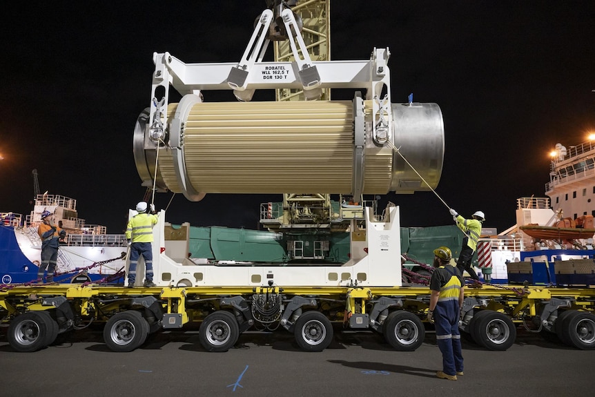 Container of nuclear waste being loaded onto truck by crane