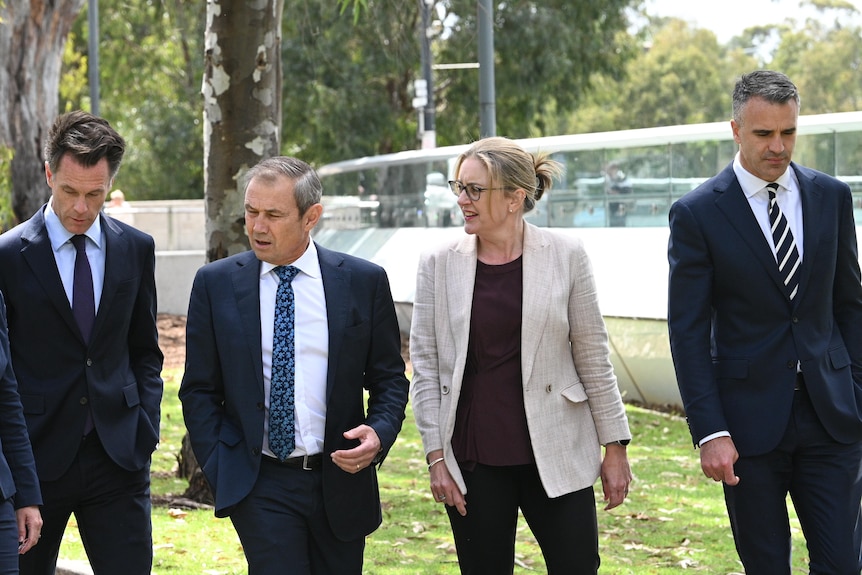 A group of politicians in suits walk together.