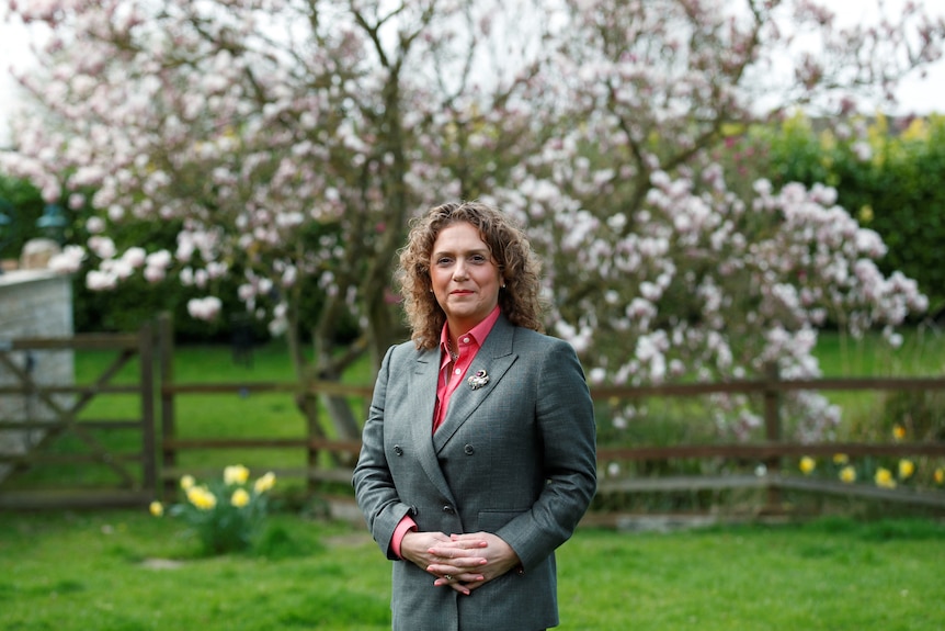 Woman posing next to tree in garden 