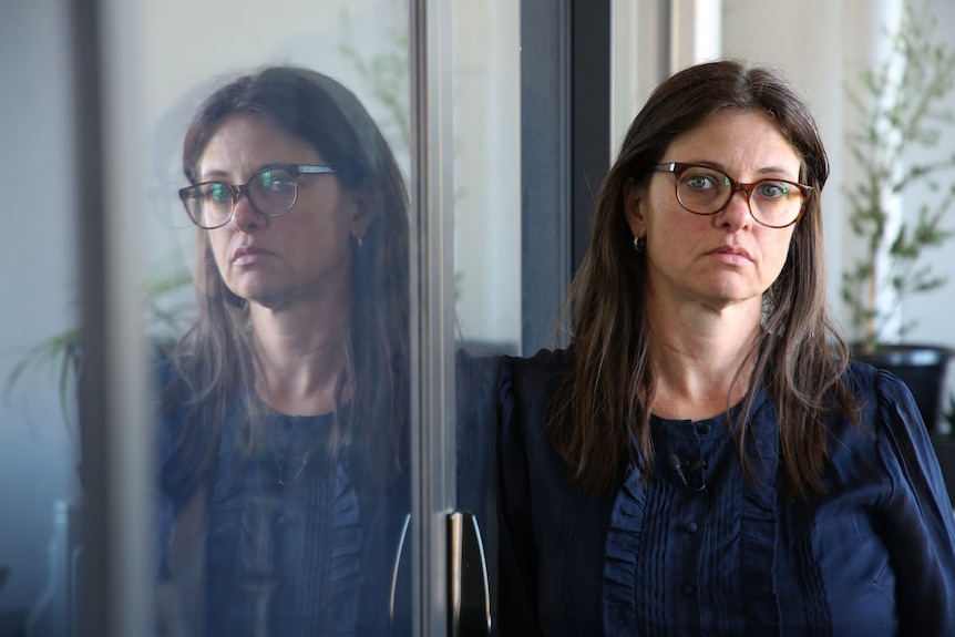 A woman standing near a reflection of herself