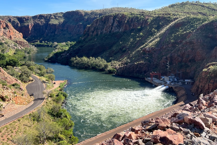 An aerial view shows a hydro power plant in front of a large lake.