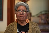 an Aboriginal woman with short grey hair wearing glasses