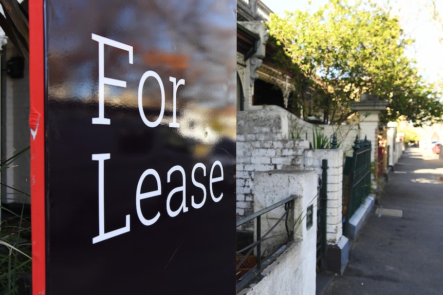 A "for lease" sign on a suburban street.