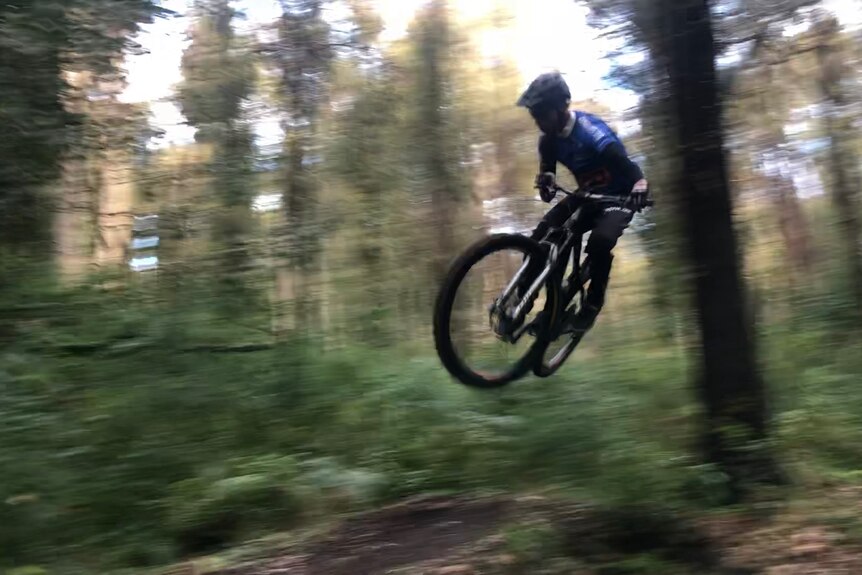 A mountain bike rider in the air.