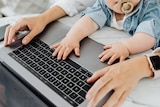 close up of mum and bub hands on laptop