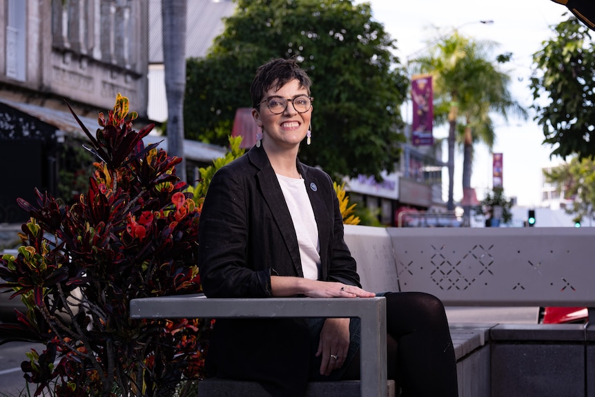 A woman sitting in an outdoor area.