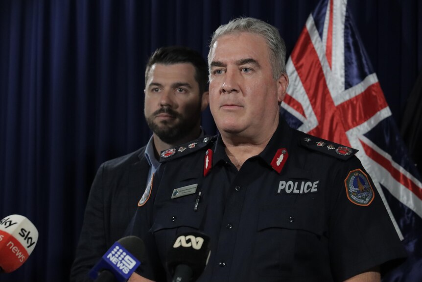 Michael Murphy at a press conference in front of an Australian flag