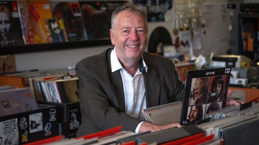 Paul Turton flipping through a stack of records in a music store.