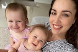 A mum with two smiley girls on her lap