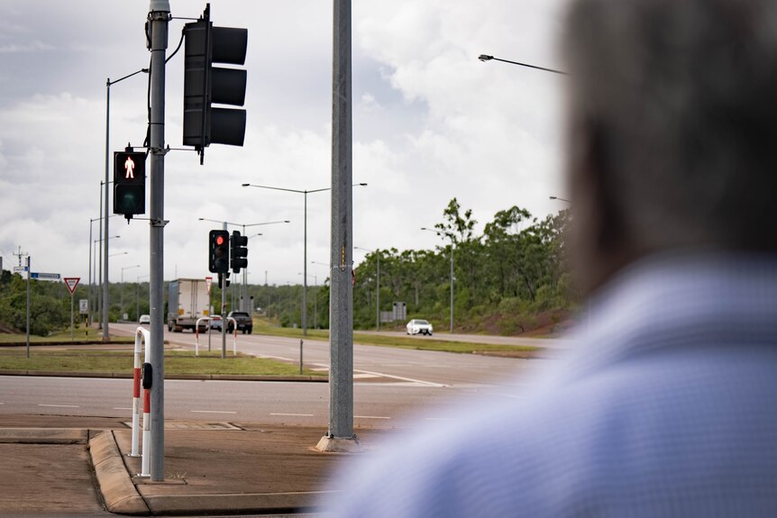 the back of a man's head with traffic lights in the background