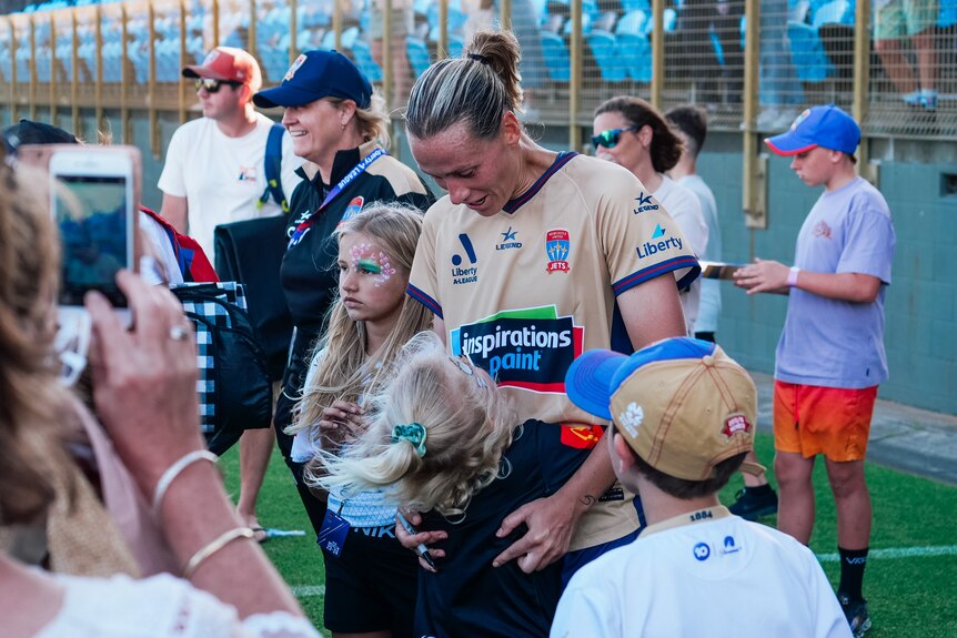 a soccer player hugs a fan