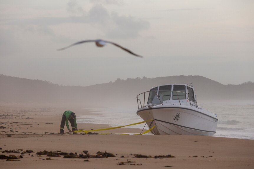 police secure an empty boat on a beach