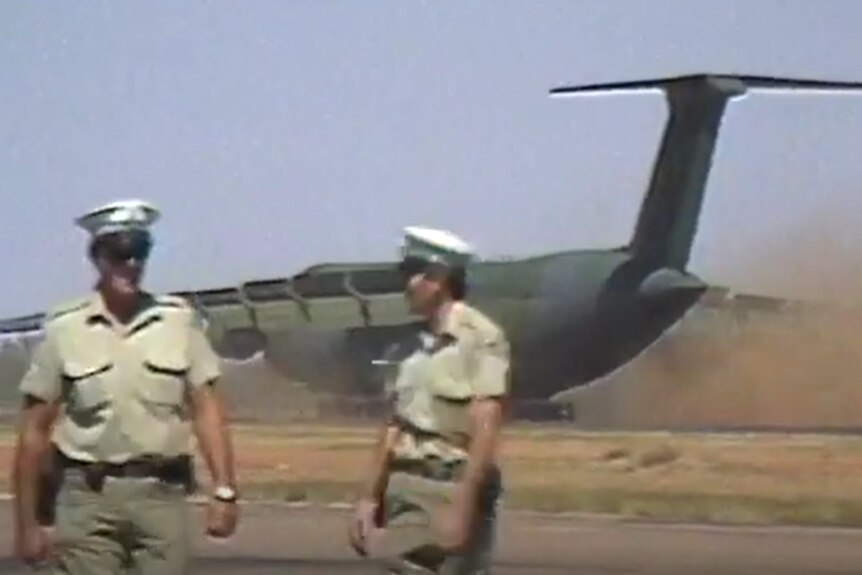 Police standing in front of Galaxy C5 as it lands in central Australia