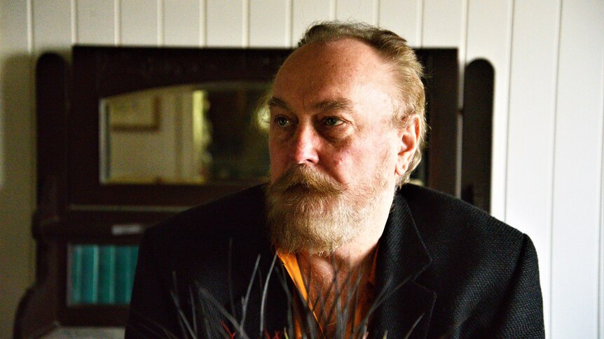 Ed Kuepper in a dapper suit, looking off-camera