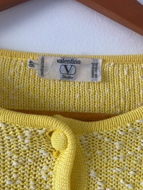 A yellow knit wool/cotton jumper with small white bobbles is seen at the yoke, including its white Valentino tag.