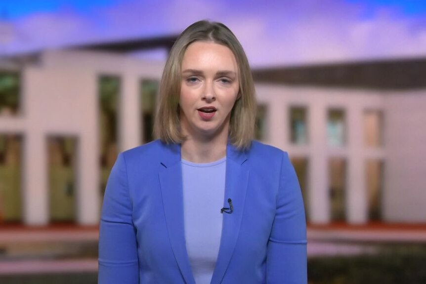 A blonde-haired reporter speaks from a telelvision studio during a news cross.