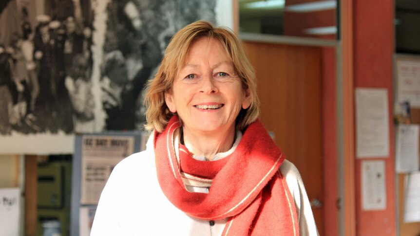 A woman wearing a red scarf smiling at the camera