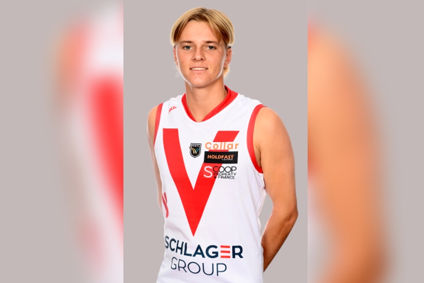 A blonde teenager poses for a photo wearing a football jersey