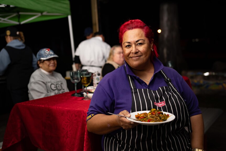 A black woman holds a plate of food