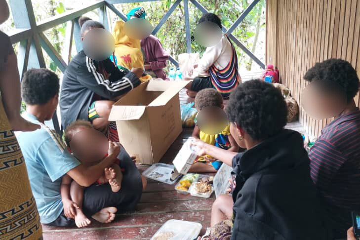 A group of PNG women and babies sitting on a verandah 