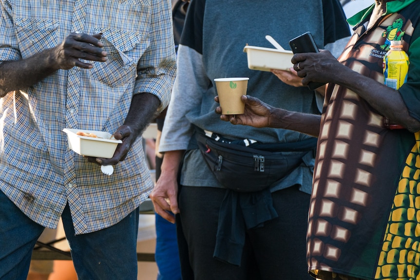 A photo showing people holding disposable cups and plates.