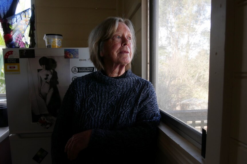 Woman standing and looking out window