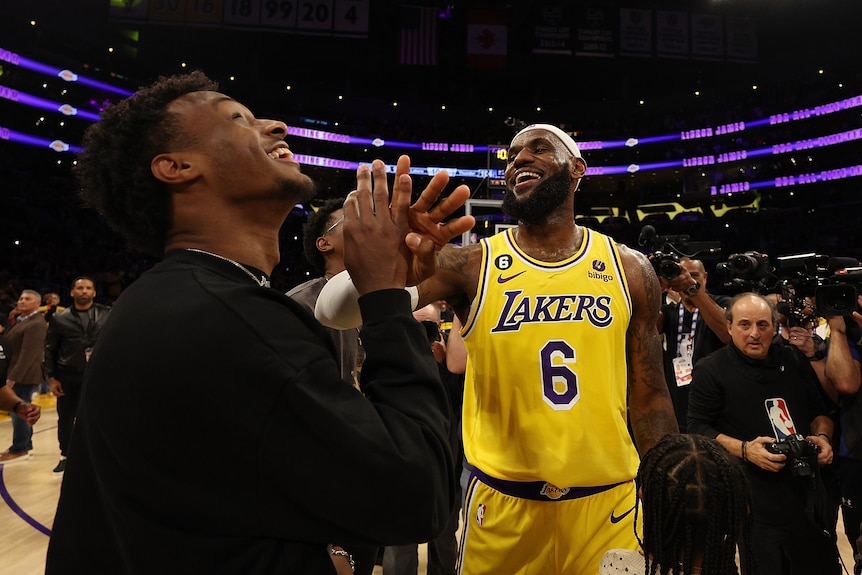 Bronny James and LeBron James share a handshake