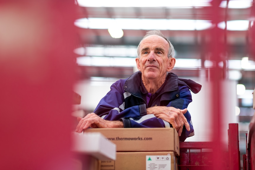 Barry Foreman leans on a box inside a Fedex warehouse