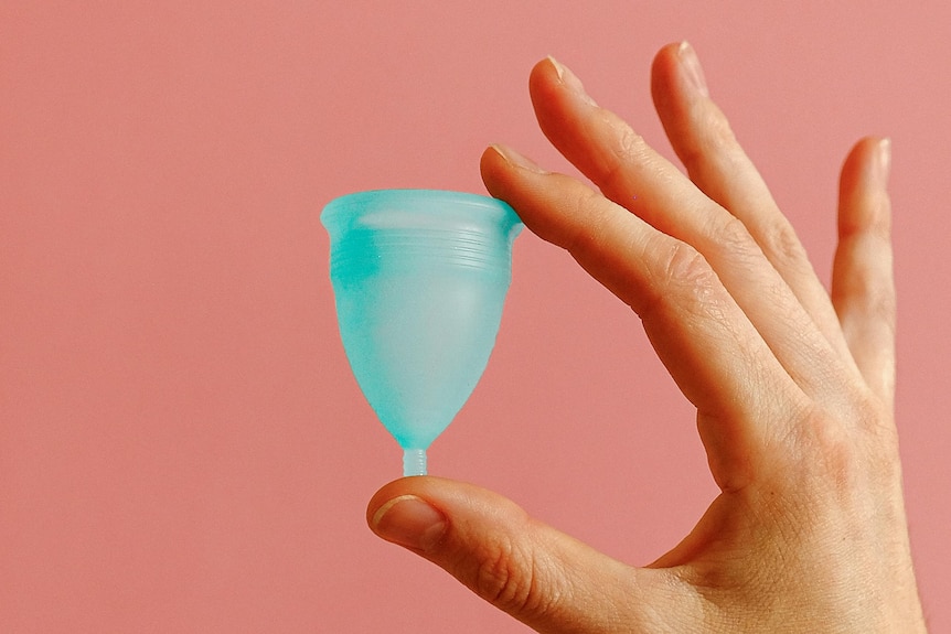 close up of hand holding a menstrual cup