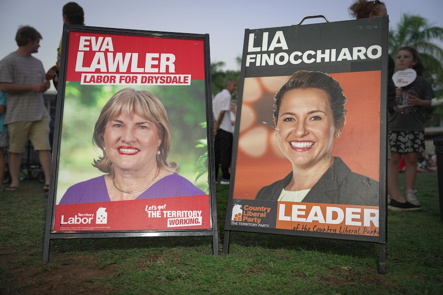 Two corflute signs side-by-side on the ground, showing the faces of NT politicians Eva Lawler and Lia Finocchiaro.