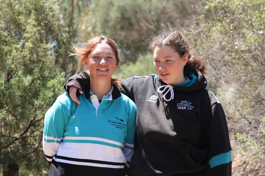 Two sisters in high school hugging