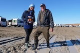 man and woman standing in the mud