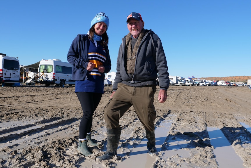 man and woman standing in the mud