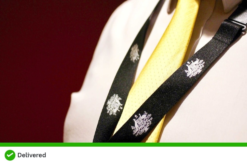 Close up of a person wearing a lanyard with the Australian Coat of Arms on it