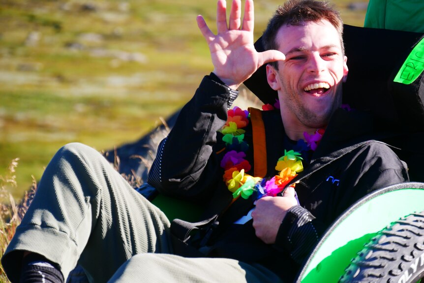 a man smiles happily from a wheelchair