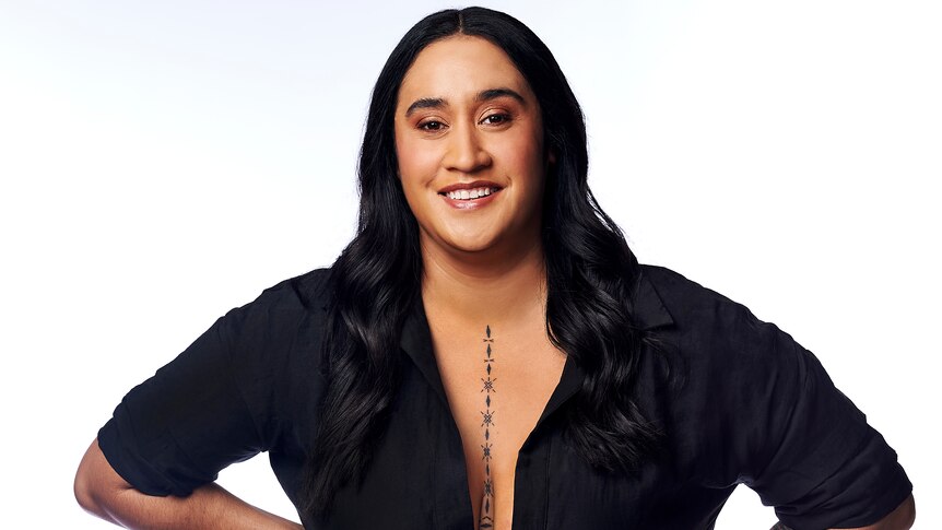 A woman wearing a black dress smiles at the camera.