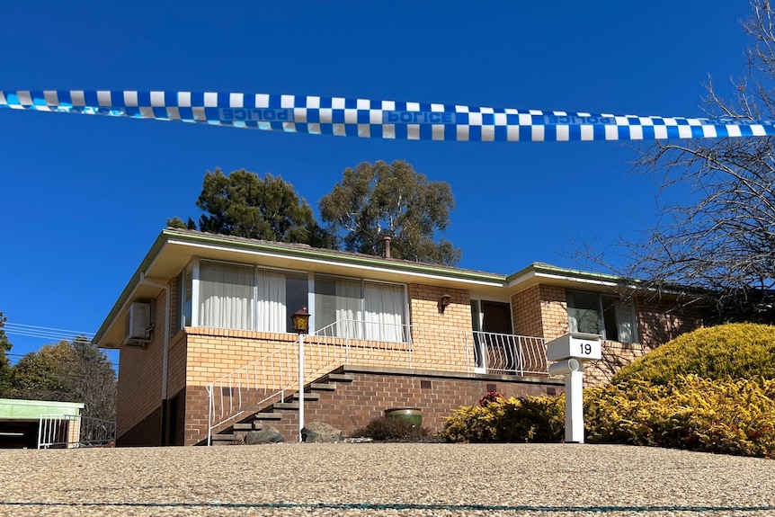 Police tape in front of a home.