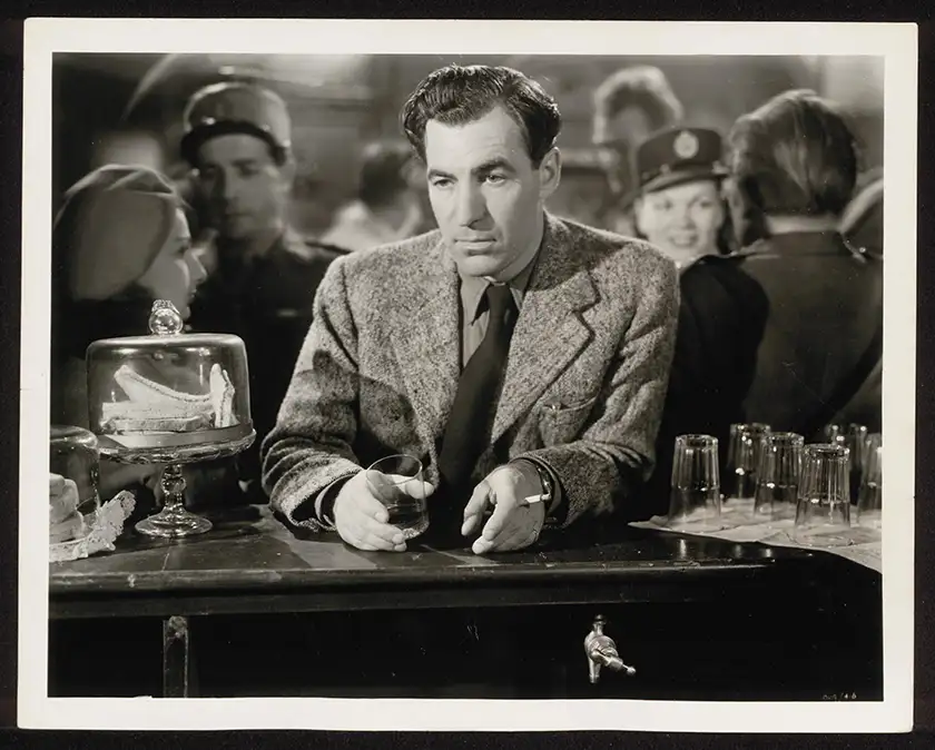 A man sits at a bar with an empty glass in his hands  in a black and white still from the Studiocanal restoration of the film The Small Back Room