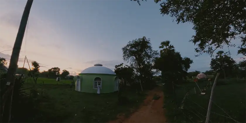 A green house and a landscape in a still from the film The Human Surge 3