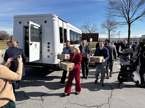 Lieutenant Governor Bethany Hall-Long and other people carrying boxes of baby formula.