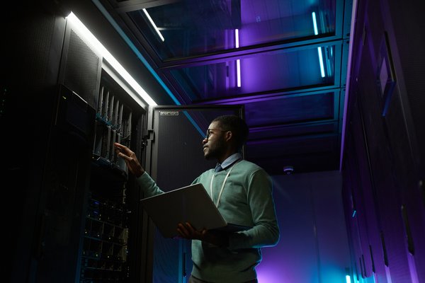 A person working at a server rack in a data center.