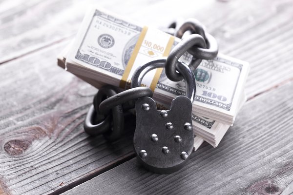 Padlock securing a bundle of cash.