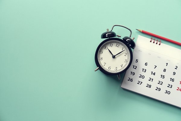 Alarm clock next to a calendar.