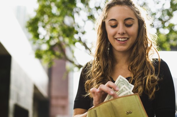 Person pulling money out of their wallet.