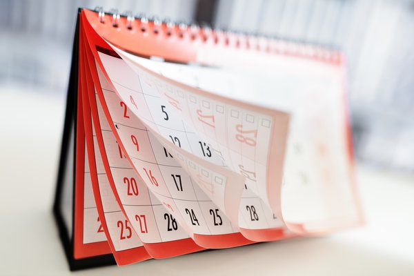 A stand-up monthly desk calendar with fluttering pages.